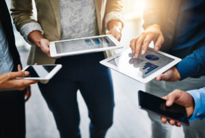 Cropped shot of unrecognizable businesspeople using their wireless devices in the office