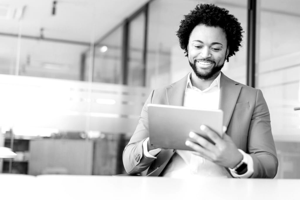 A black man engaged in elearning on his tablet